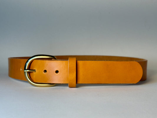 Golden honey leather belt with a gold buckle on a light gray background